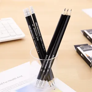 Detailed view of several black 2B hexagonal pencils placed in a clear glass on a desk.