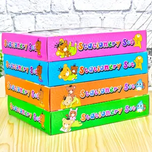 Pila di set di cancelleria colorati per bambini in scatole rosa, blu, arancioni e verdi.