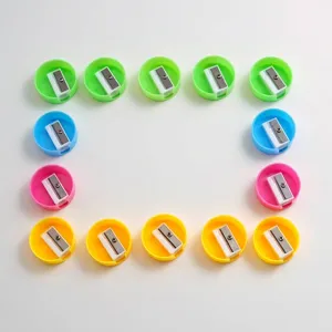 Detailed top-down view of colorful mini round pencil sharpeners arranged in a square frame.