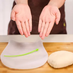 Close-up view of translucent silicone kneading bag with green tie on wooden board