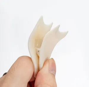 Detailed close-up view of a white plastic eyelash applicator tool held by a hand