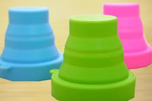Gobelets pliables en silicone colorés en bleu, vert et rose pour l'usage extérieur.