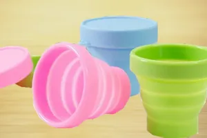 Vue détaillée de tasses pliables en silicone colorées avec couvercles pour le voyage.