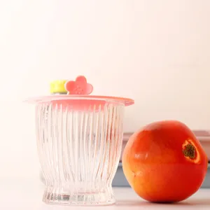 Detail view of a pink flower-shaped silicone lid on a ribbed glass cup for home use