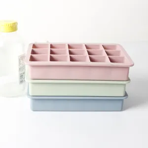 Close-up view of stacked 15-grid silicone ice cube molds in pink, green and blue