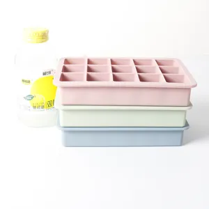 Close-up view of stacked 15-grid silicone ice cube trays in pink, green and blue