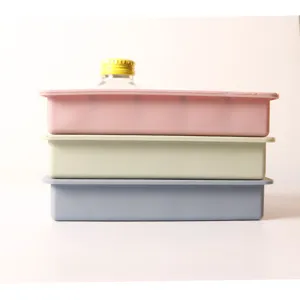 Detailed side view of stacked pink, light green, and blue silicone ice cube trays with lids.