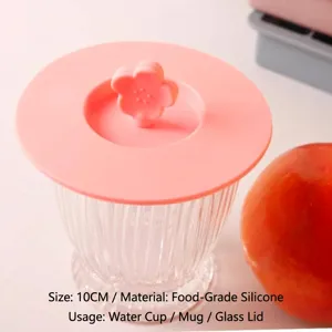 Flower-shaped pink silicone cup lid for mugs and glasses, 10cm food grade material detail.