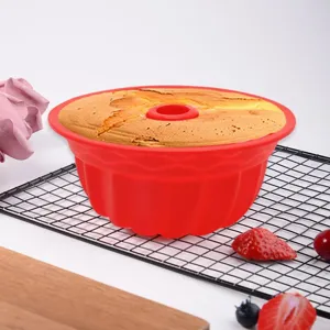 Close-up of baked cake inside a red fluted silicone mold on a wire cooling rack
