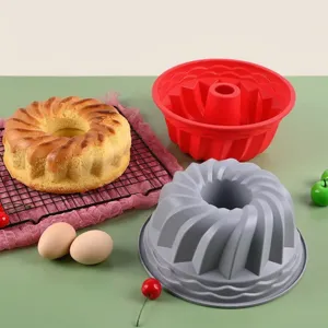 Detail view of red and gray fluted silicone cake molds with a freshly baked bundt cake