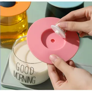 Detail of food-grade pink silicone cup lid being assembled on a milk glass.