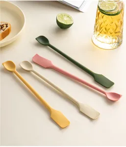 Detailed view of four colorful double-ended silicone jam spatulas and spoons on a table