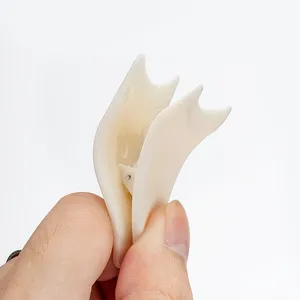 Professional cream white plastic false eyelash applicator tool held by hand for makeup