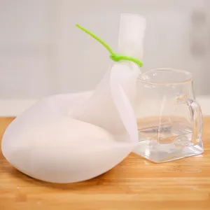 Food-grade silicone kneading bag for dough with green silicone tie on wooden board