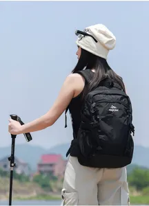Vista dettagliata di uno zaino da trekking nero indossato da un modello all'aperto