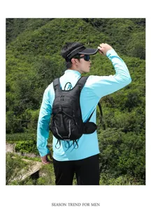 Asian man wearing a black lightweight marathon running backpack in lush mountain scenery