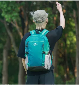 Vista dettagliata dello zaino da trekking leggero color verde acqua indossato all'aperto