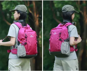 Zaino da trekking rosa e grigio indossato da una modella in un ambiente naturale