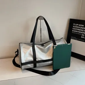 Vista laterale di una borsa da palestra argento accanto a un tablet verde per il confronto.
