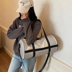 Vista laterale di una grande borsa sportiva cilindrica argento portata da modella asiatica