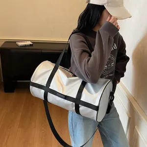 Grande borsa da viaggio cilindrica bianca portata da una persona con un abbigliamento casual