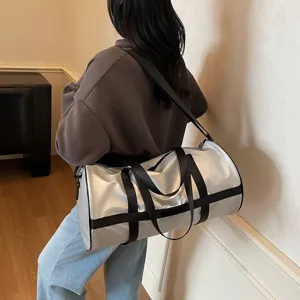 Borsone sportivo argento capiente portato da modella in un interno elegante e moderno