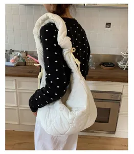 Detailweergave van witte gewatteerde cloud hobo tas met hartborduursel op de schouder