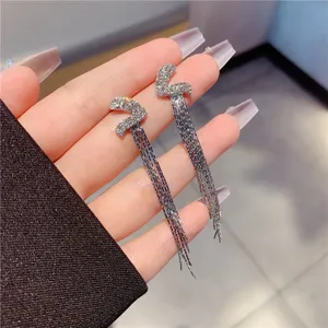 Elegant sparkling rhinestone long tassel drop earrings shown in a hand-held detail view