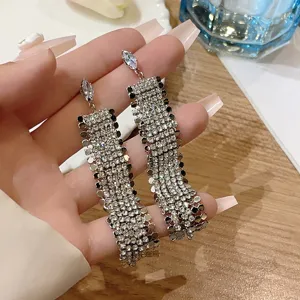 Detailed view of long silver tassel earrings featuring sparkling rhinestone fringe