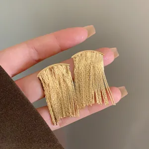 Close-up detail of elegant gold fringe tassel drop earrings with unique textured finish