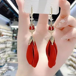 Close-up of elegant long red petal earrings with sparkling cubic zirconia accents