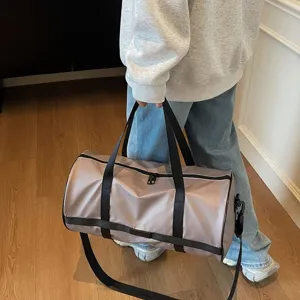 Primo piano di una grande borsa da viaggio malva tenuta da una persona in un interno.