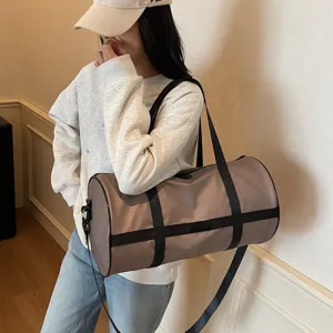 Modella che porta una grande borsa sportiva cilindrica color malva sulla spalla in un interno