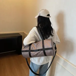 Borsa fitness kaki capiente portata a spalla in un ambiente dal design moderno e sportivo