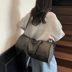 Dettaglio di una grande borsa sportiva grigio scuro portata a spalla su una scala