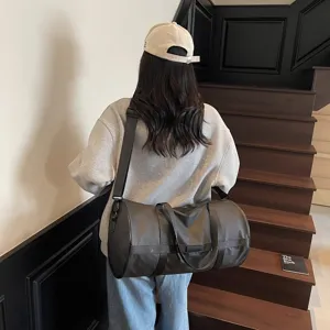 Vista posteriore di una modella che indossa una grande borsa da palestra cilindrica grigia