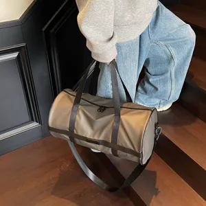 Dettaglio di una borsa da palestra kaki di grande capacità trasportata sulle scale.