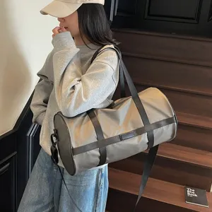 Vista casual di una grande borsa da palestra in nylon taupe portata comodamente a spalla.