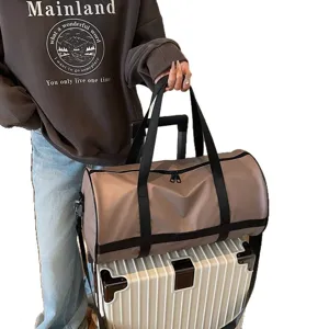 Borsa da viaggio capiente color tortora elegante per sport su valigia bianca