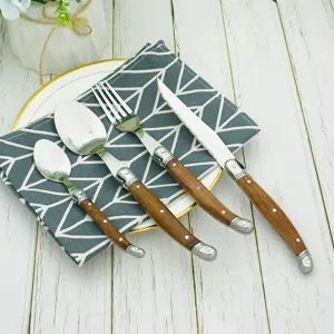 Detailed view of Laguiole-style stainless steel cutlery with ergonomic wooden handles.