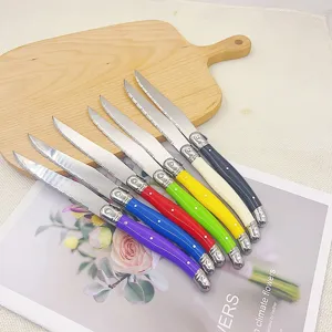 Detailed view of 7 colorful Laguiole steak knives featuring serrated stainless steel blades