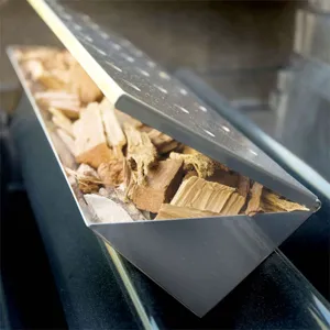 Close-up of a stainless steel V-shape smoker box filled with natural wood chips for BBQ smoking