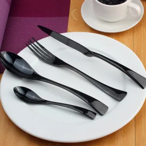Elegante zwarte roestvrijstalen bestekset met glanzende afwerking op een wit keramisch bord