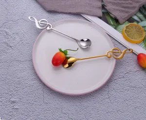 Creative musical note coffee spoons in gold and silver stainless steel on a plate