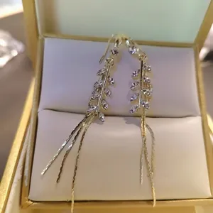 Detail of elegant wheat ear tassel earrings with clear cubic zirconia in a gift box.
