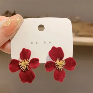 Vintage-style red flocked flower stud earrings with golden stamens on display card.