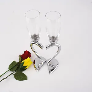Detail view of crystal champagne glasses featuring unique silver heart-shaped stems and bases.