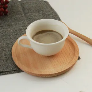 Vista detallada de una bandeja redonda de madera de haya para una taza de café y postre