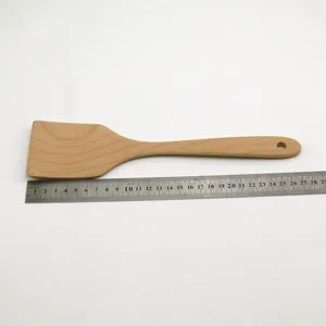 Beech wood cooking spatula shown with a stainless steel ruler for size measurement detail.