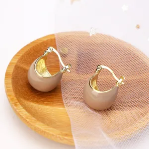 Detailed macro view of elegant retro caramel enamel hoop earrings with a gold-toned finish